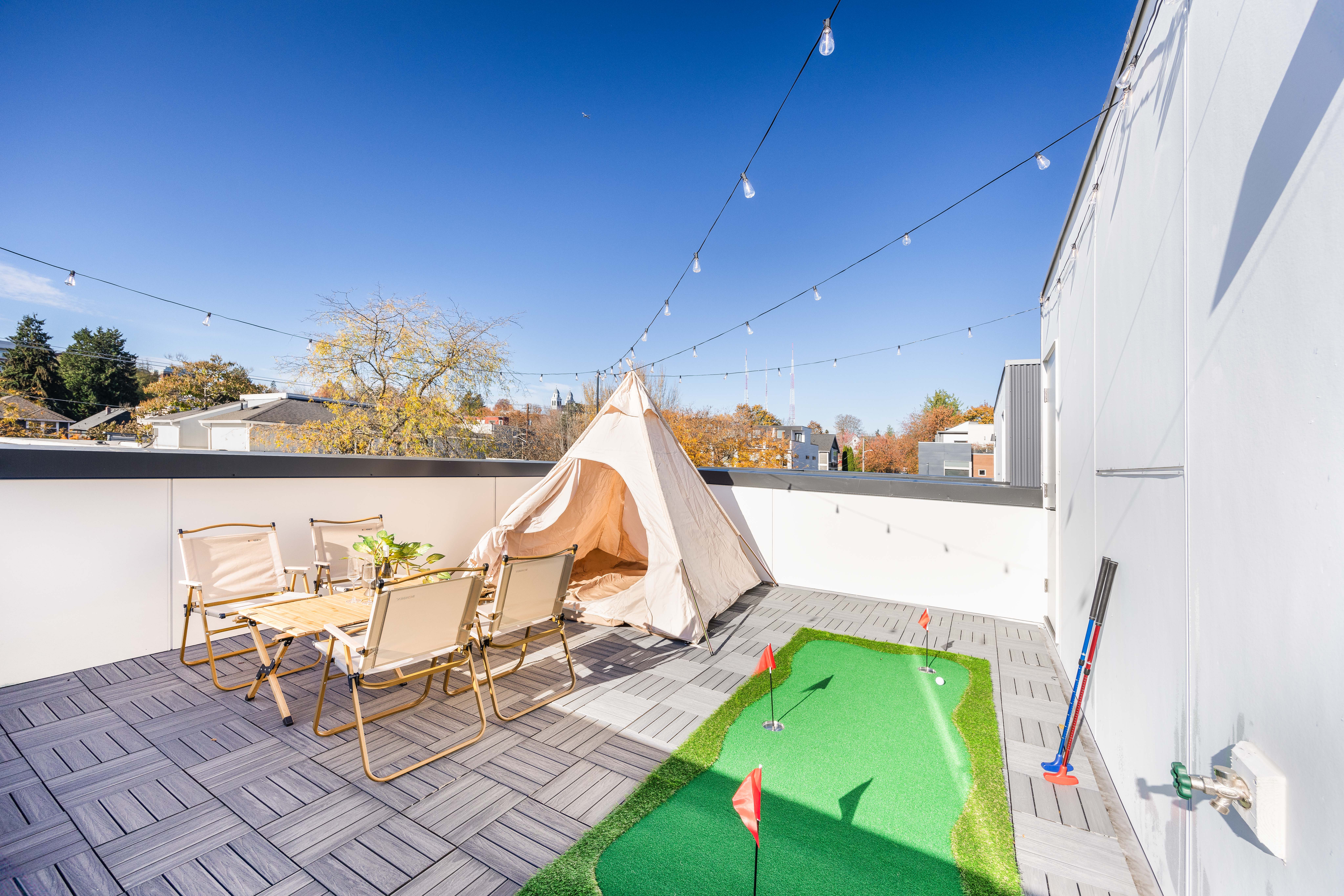 Rooftop patio with putting green, glamping tent, and string lights — Seattle vacation rental